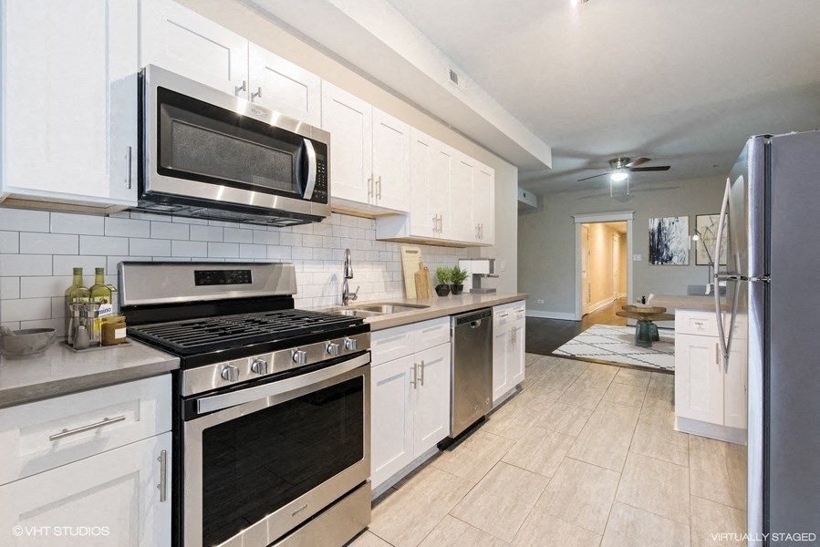 a kitchen with stainless steel appliances and white cabinets
