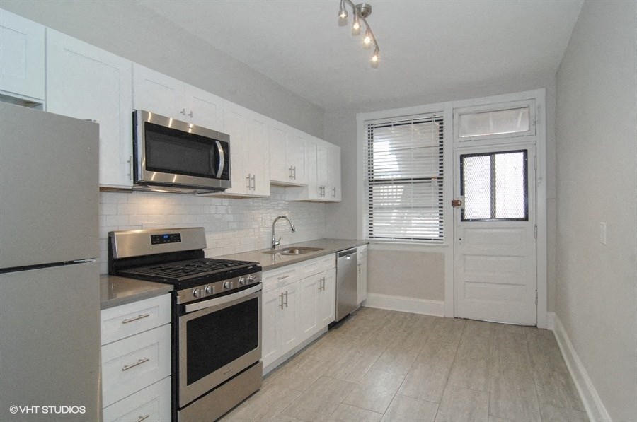 a kitchen with white cabinets and a stove and a microwave