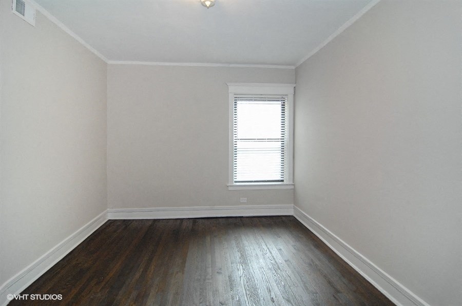 an empty room with white walls and wooden floors and a window