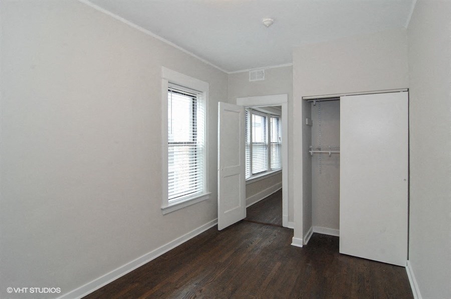 an empty room with white walls and a closet with two windows