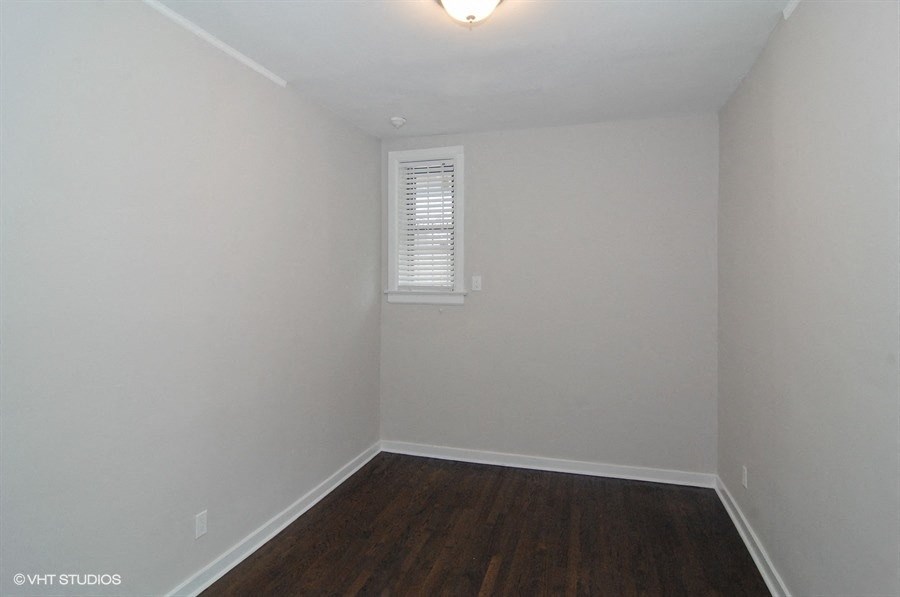 an empty room with white walls and wooden floors and a window