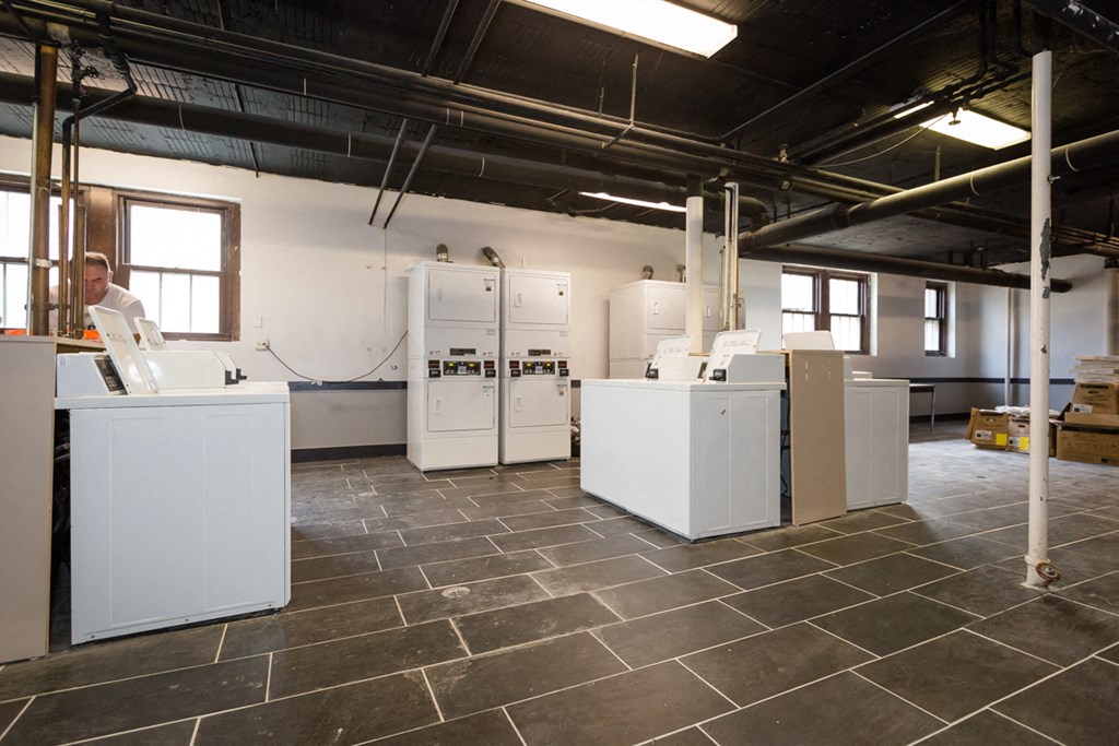 a kitchen area with white appliances in a building