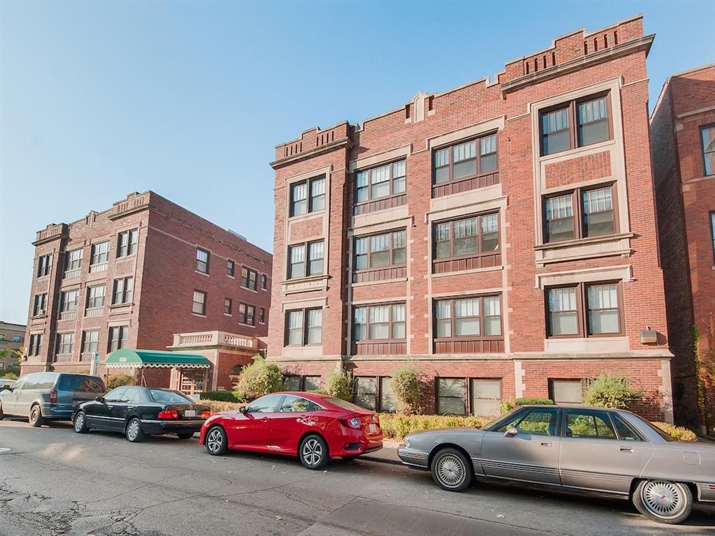 a row of cars parked in front of a brick building