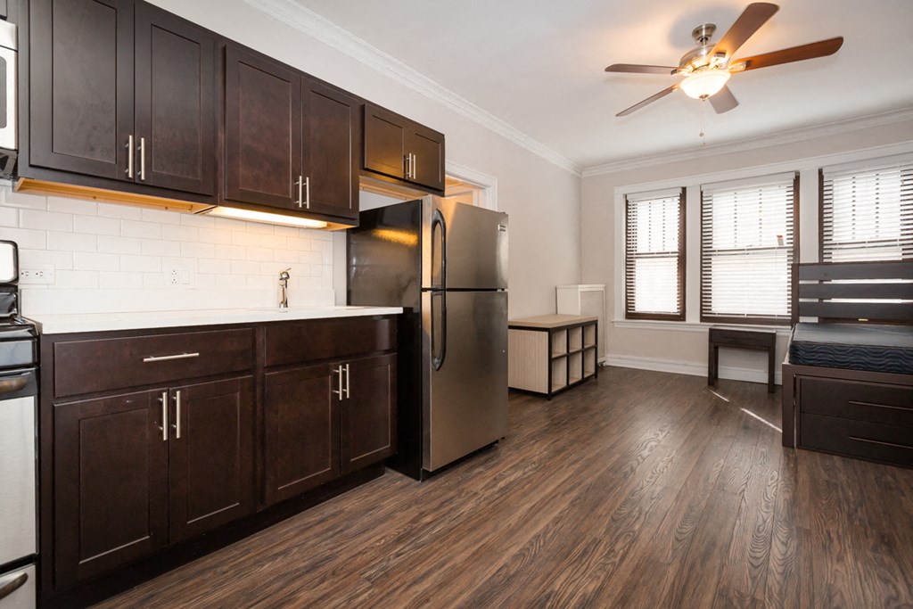 a kitchen with dark wood cabinets and a stainless steel refrigerator