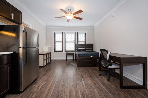 a kitchen and living room with a refrigerator and a desk