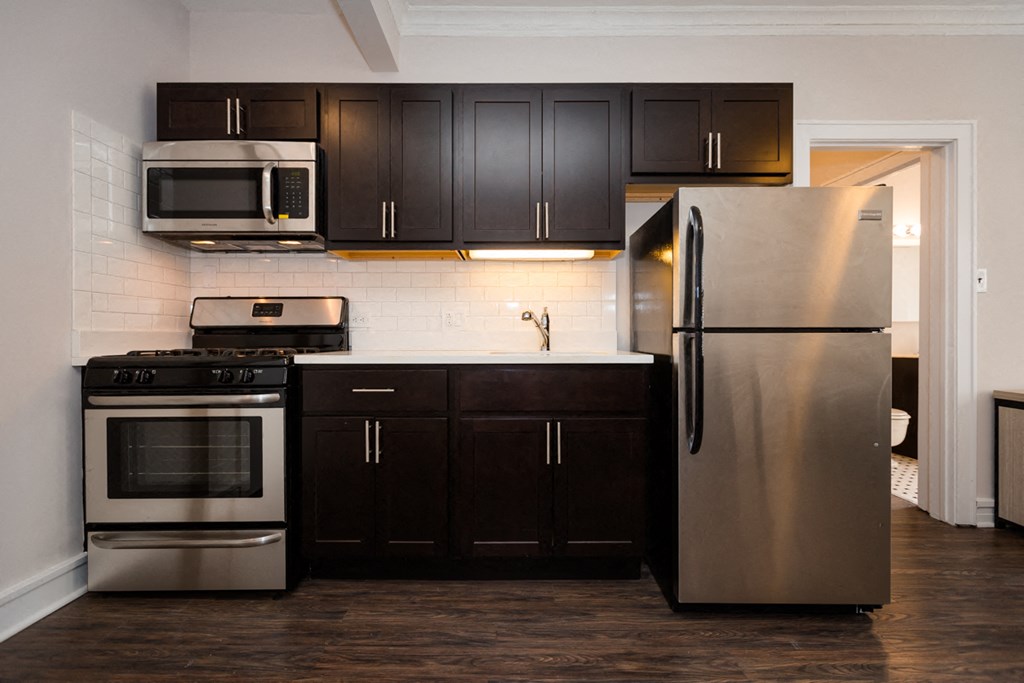 a kitchen with stainless steel appliances and black cabinets