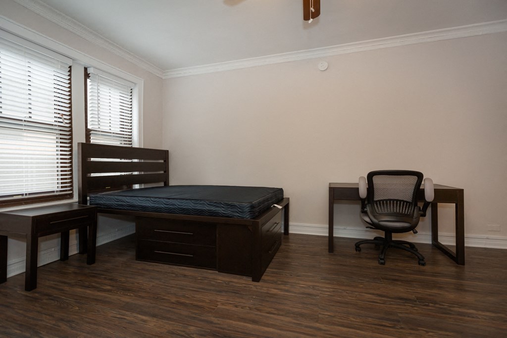 an empty room with a bed and a desk and a chair