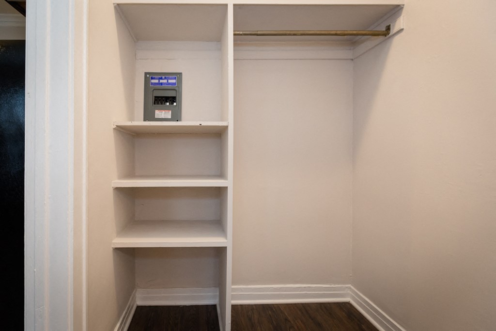 a walk in closet with shelves and a meter in it