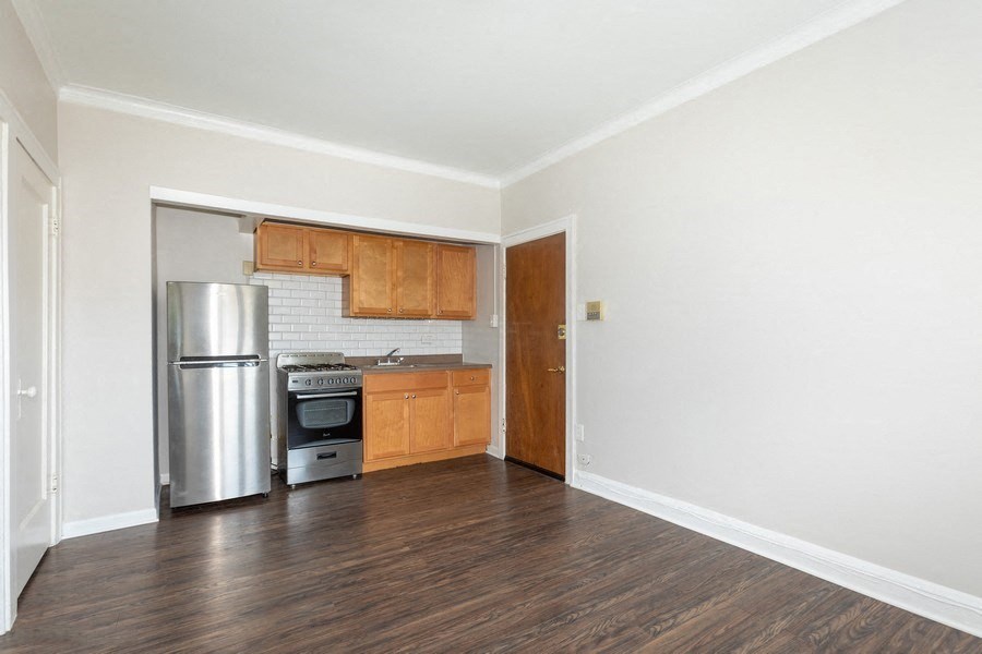 the spacious kitchen with stainless steel appliances and wood flooring