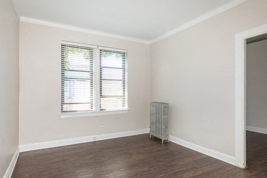 an empty room with a radiator and a window