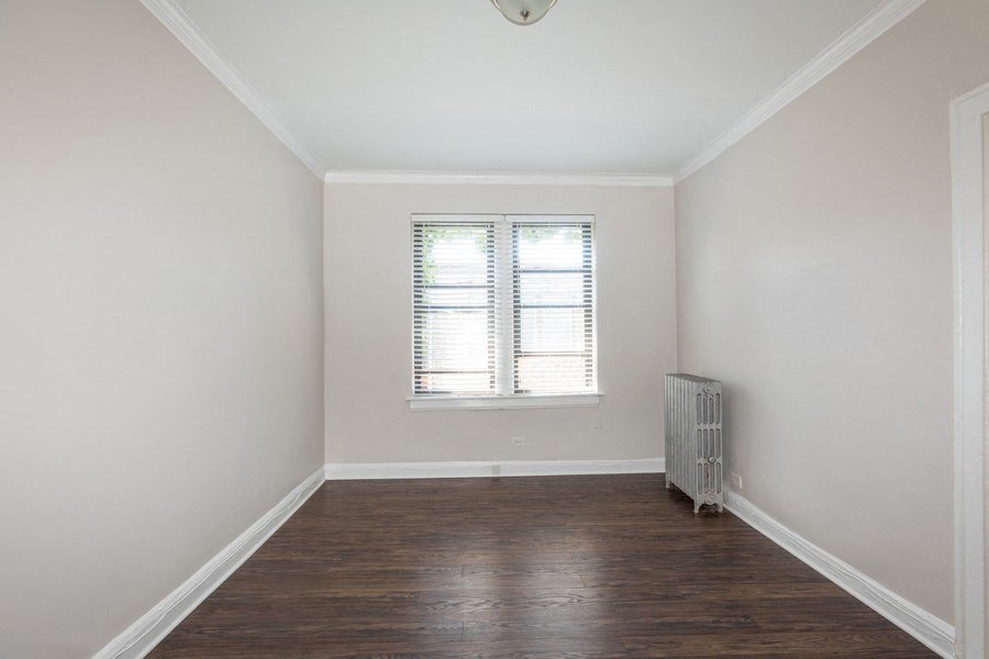 an empty room with a radiator and a window