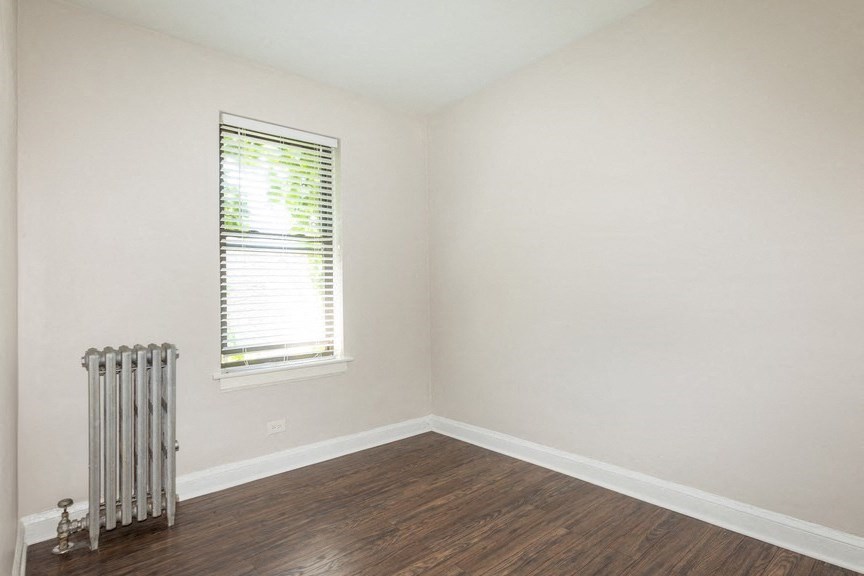 an empty room with a radiator and a window