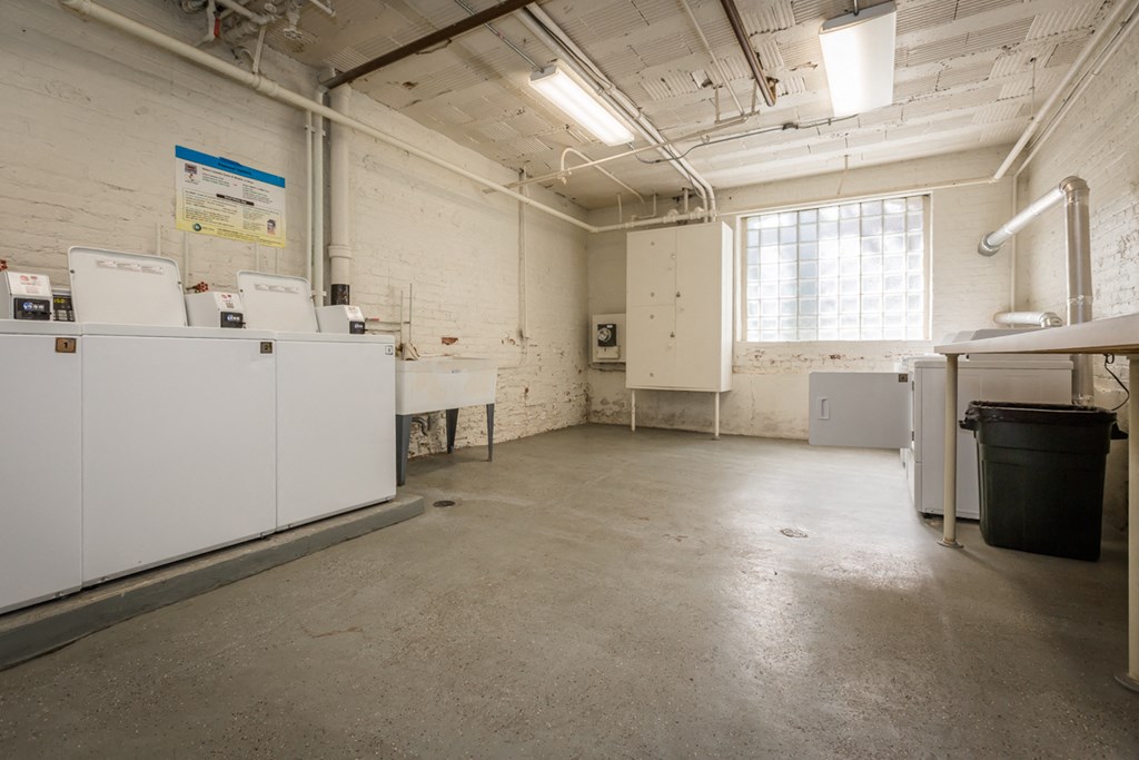 a laundry room with washing machines and sinks and a window