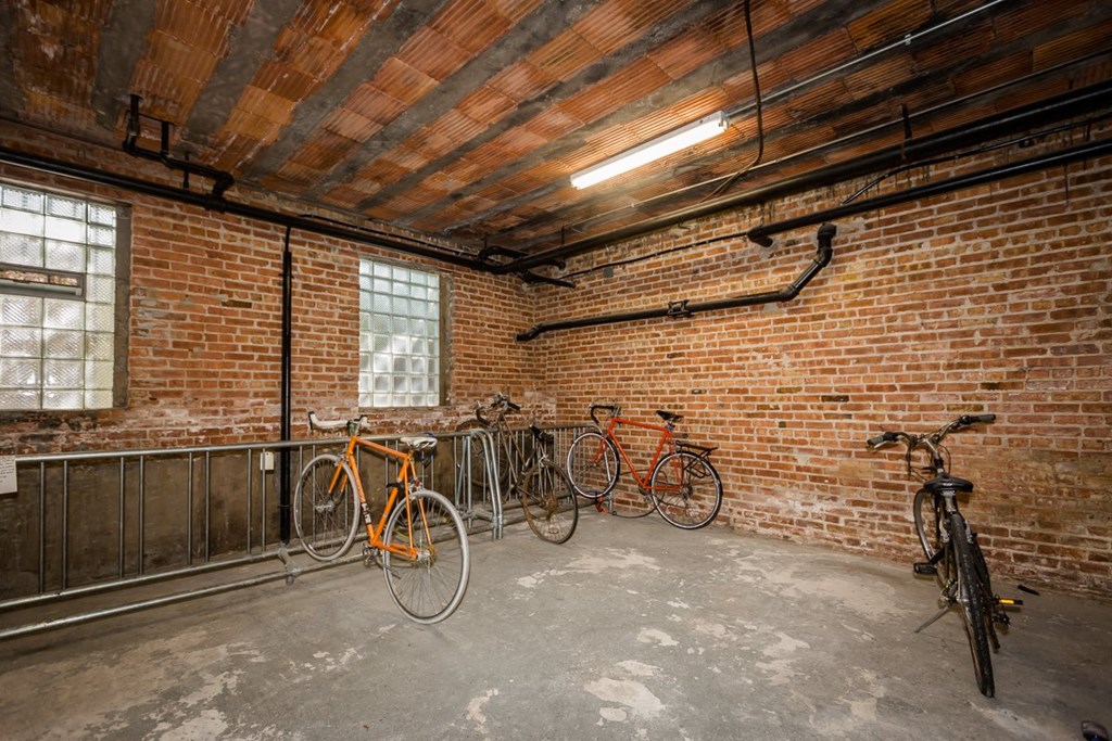 three bikes parked in a brick room with a brick wall