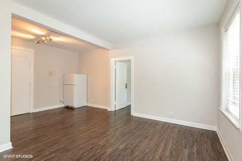 the living room of an empty house with a refrigerator