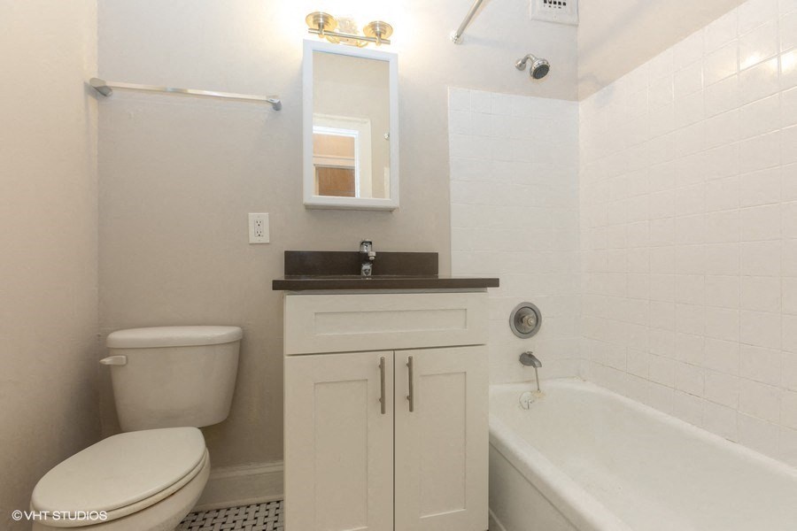 a white bathroom with a toilet and a tub and a sink
