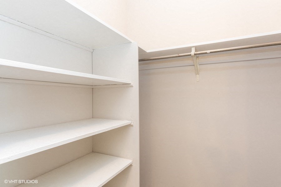 an empty closet with white shelves and a white