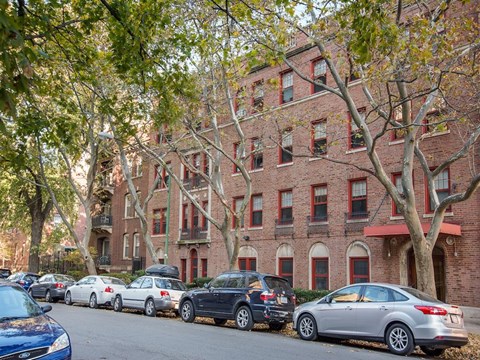a row of cars parked in front of a brick building