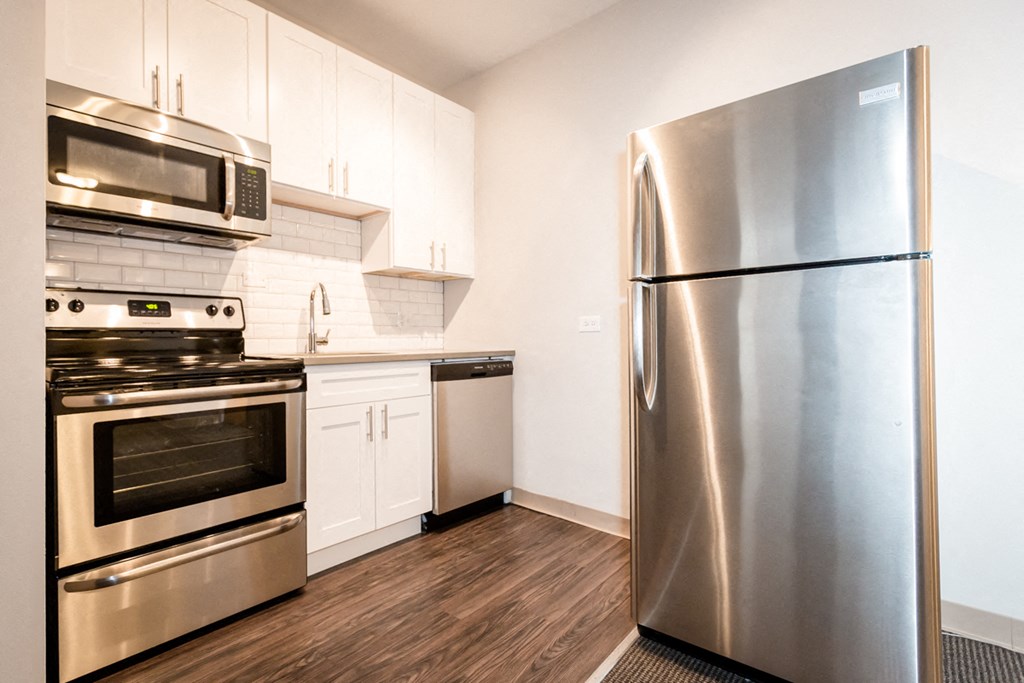 a kitchen with stainless steel appliances and white cabinets