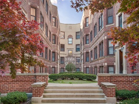 a view of an apartment building with stairs and a garden