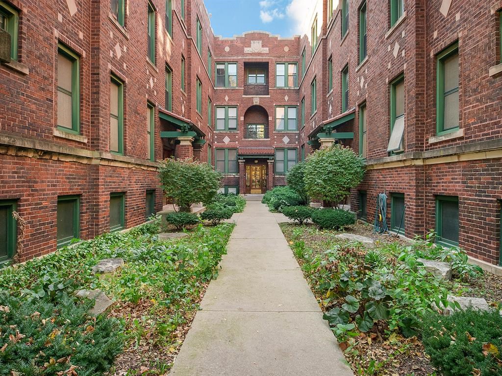 a sidewalk in a courtyard between two brick buildings