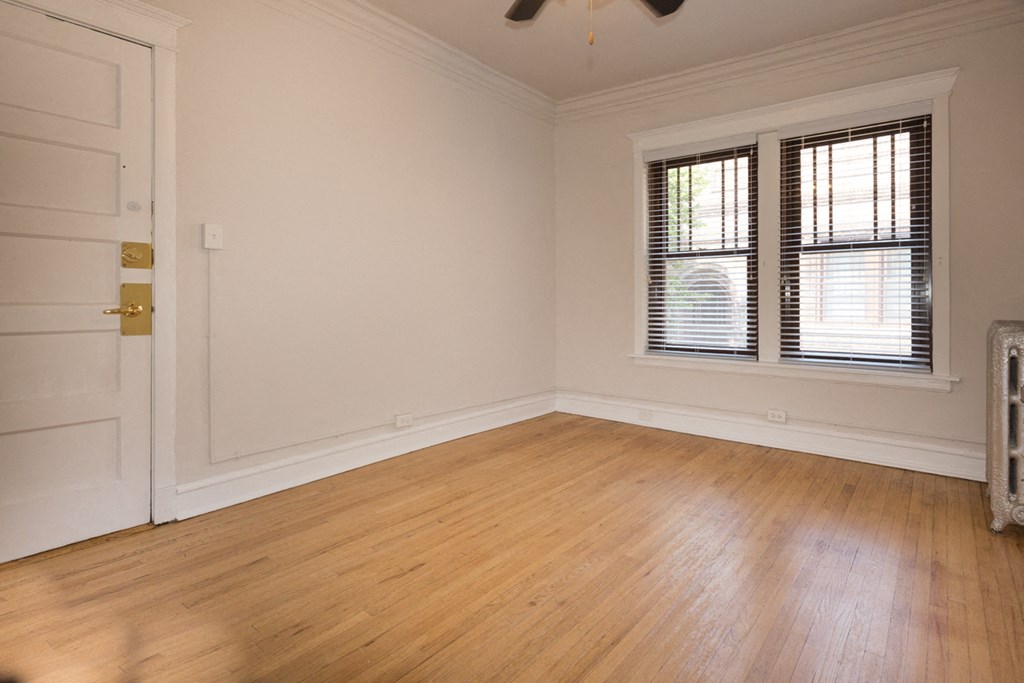 an empty living room with wood floors and a door and window