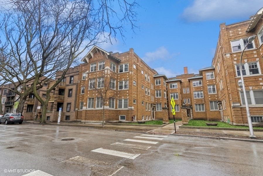 an empty street in front of a brick apartment building