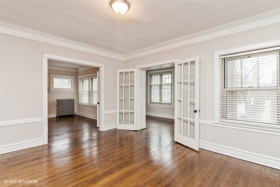 the living room and dining room of a renovated house with white walls and wood floors
