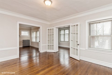 the living room and dining room of a renovated house with white walls and wood floors