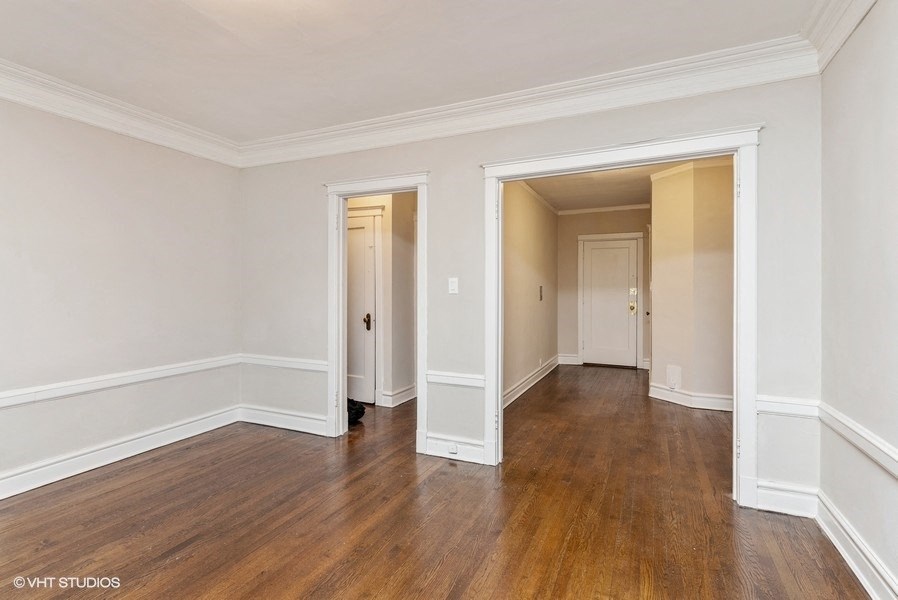 the living room and dining room of a house with wood floors and white walls