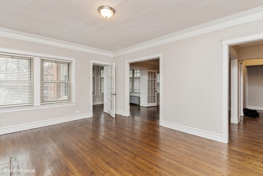 the living room and dining room of a house with wood floors and white walls