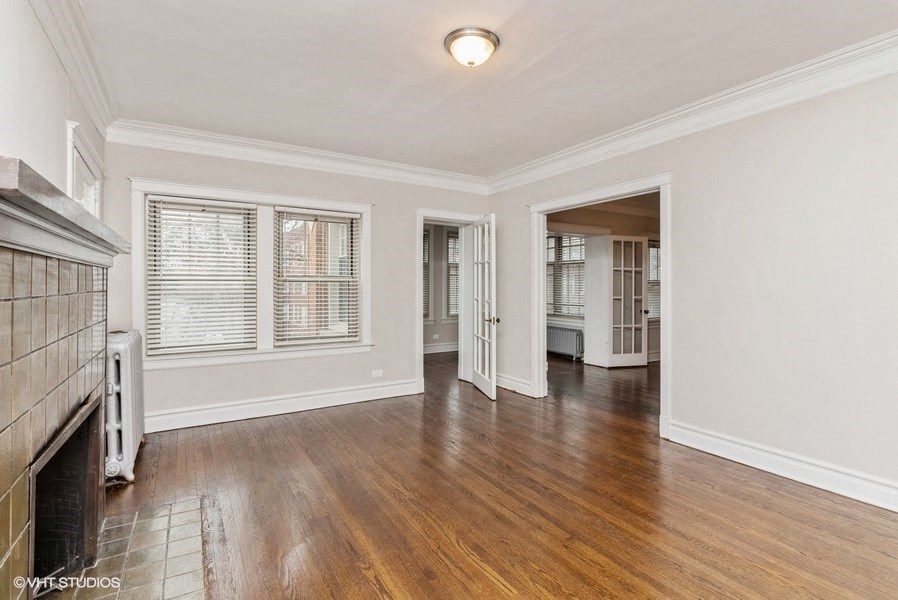 the living room and dining room of a house with wood floors and a fireplace