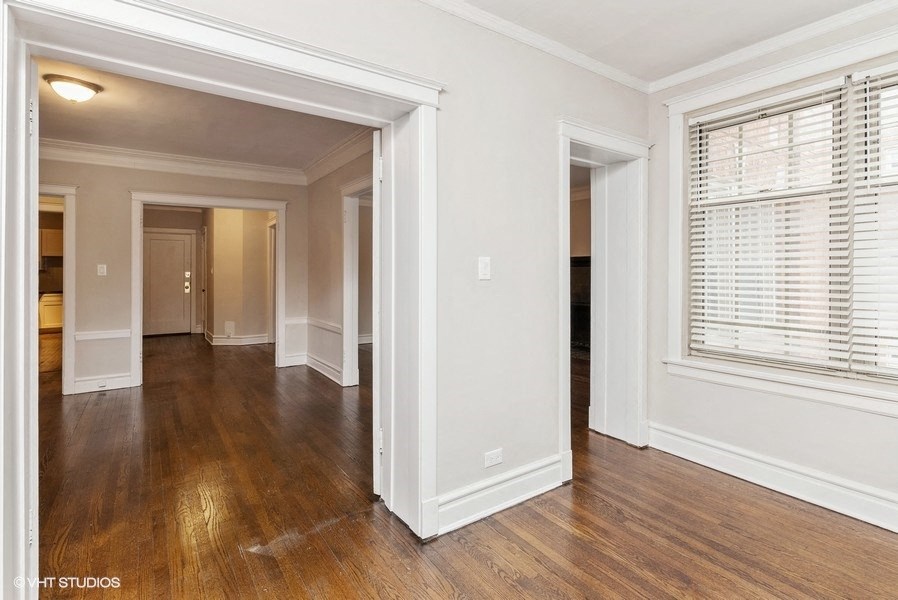 the living room and dining room of a house with wood floors and a large window