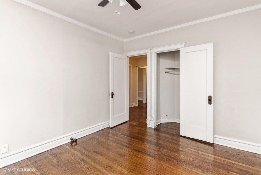 an empty room with white walls and wood floors and a closet