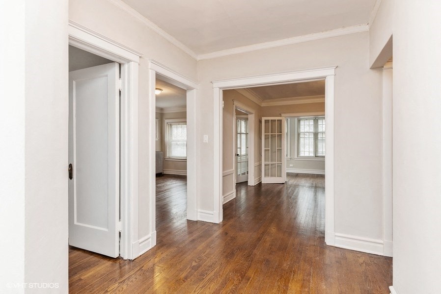 the living room and dining room of a renovated house with white walls and wood floors