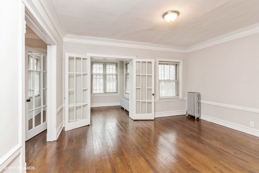 an empty living room with white walls and a wood floor