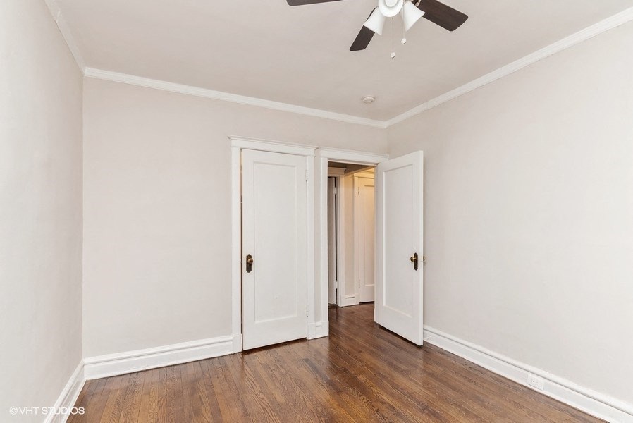the living room of an empty house with white walls and a ceiling fan