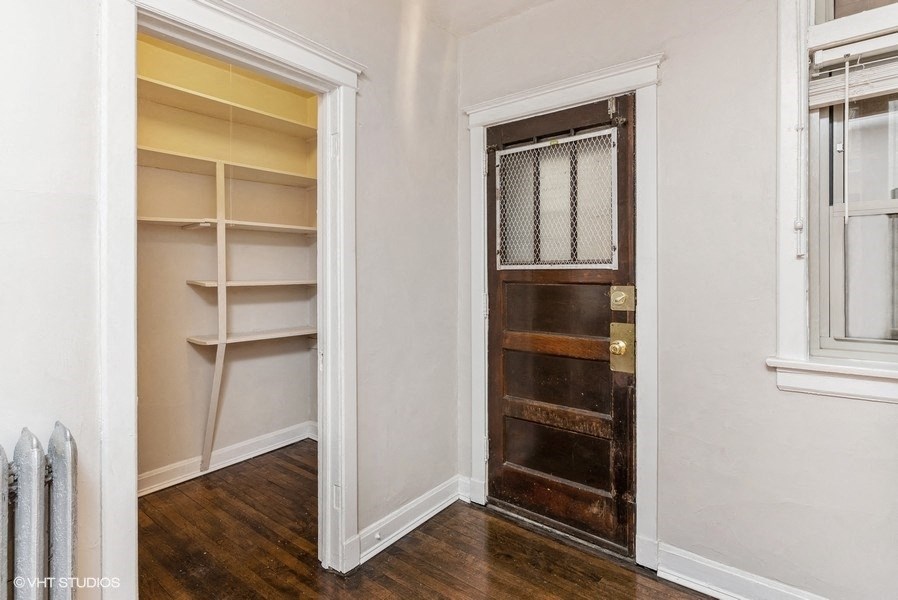 a small room with a door to a closet and shelves