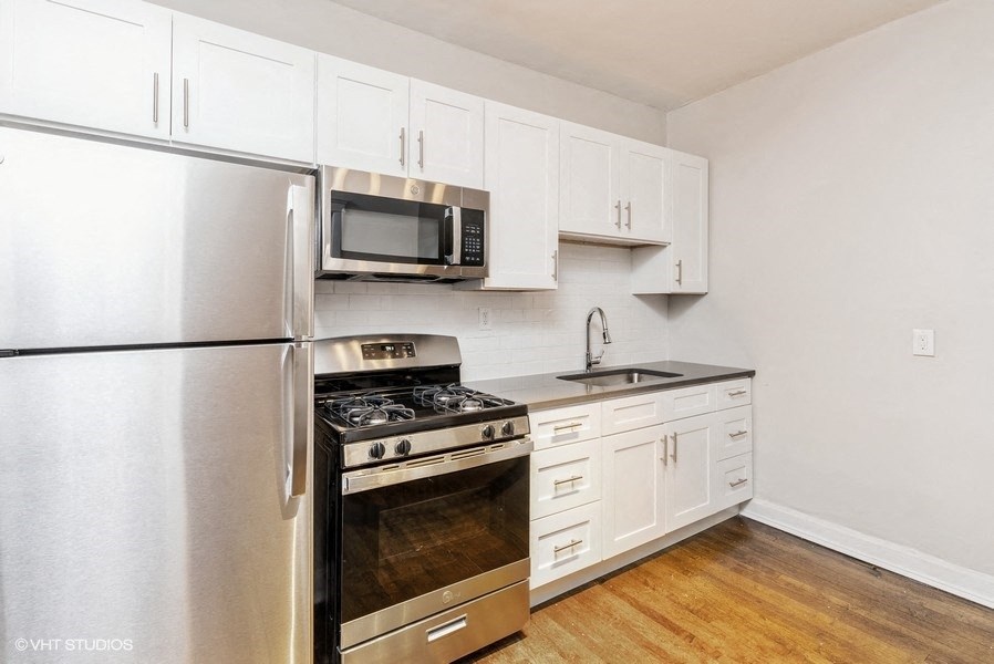 a kitchen with stainless steel appliances and white cabinets