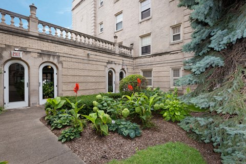 the outside of a building with a garden in front of it