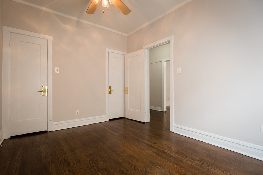 an empty living room with wood floors and white walls
