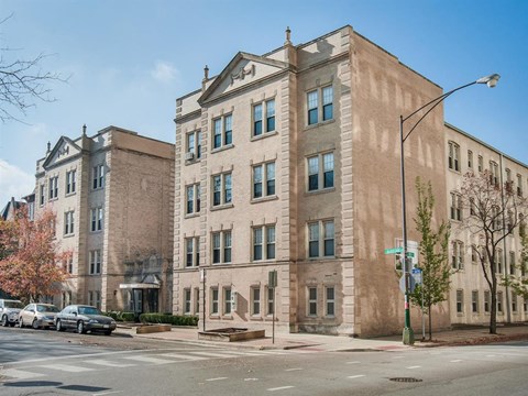 the apartment building is on the corner of a city street
