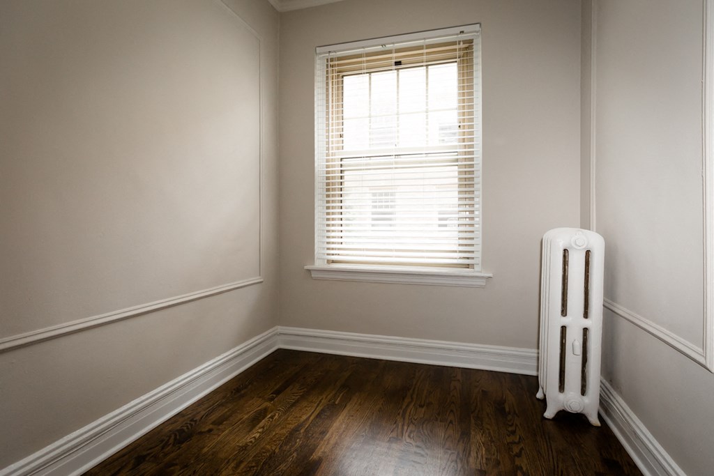 a radiator in the corner of a room with a window