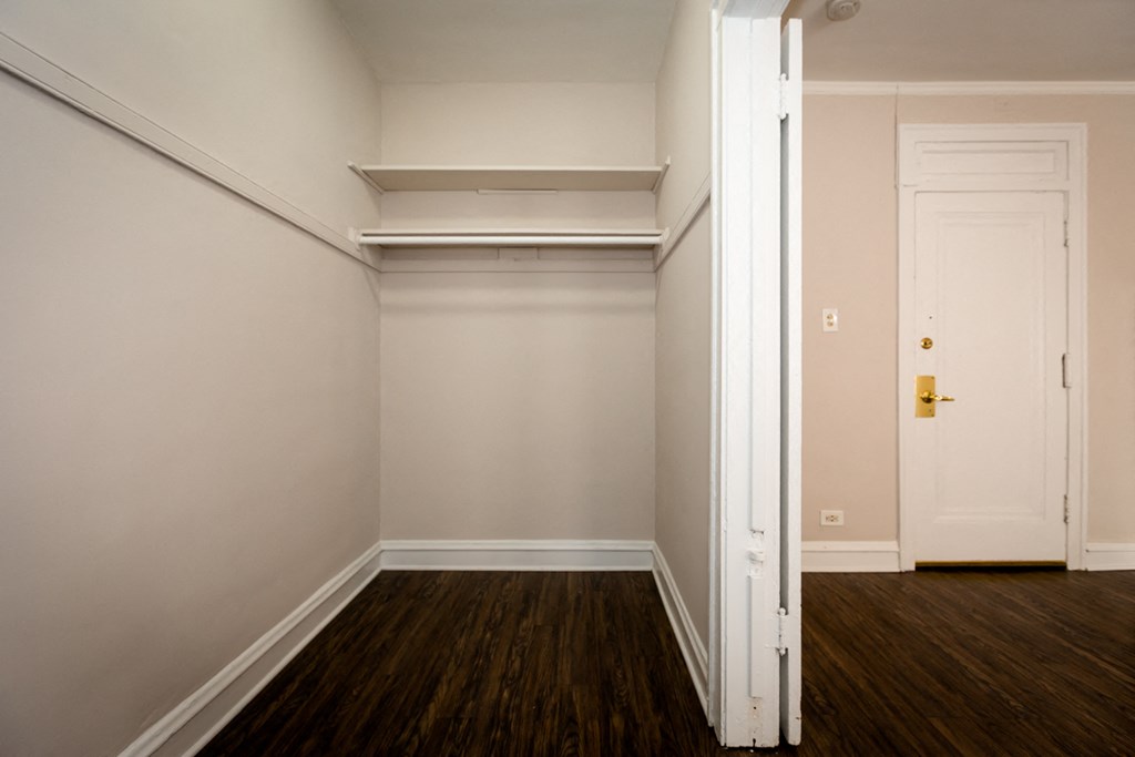 an empty room with wooden floors and a white door
