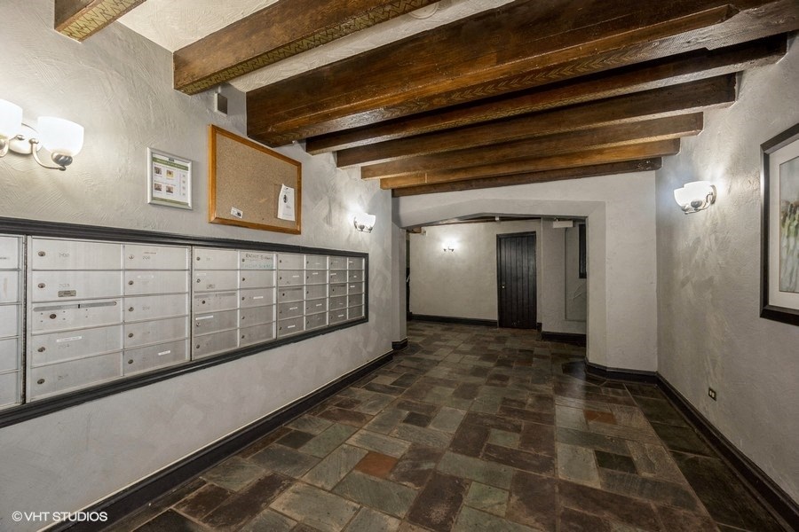 a long hallway with a row of mailboxes and a door in a building