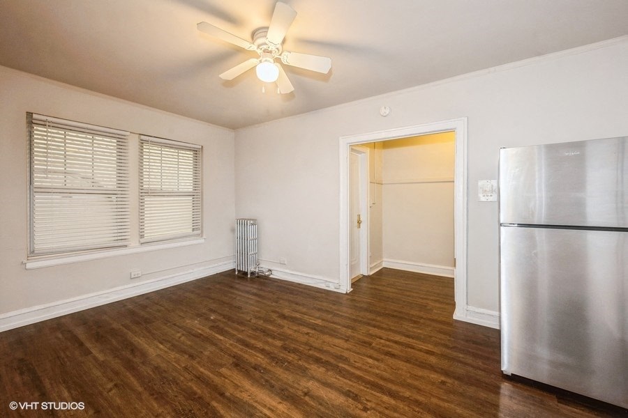 the living room of an empty house with a refrigerator