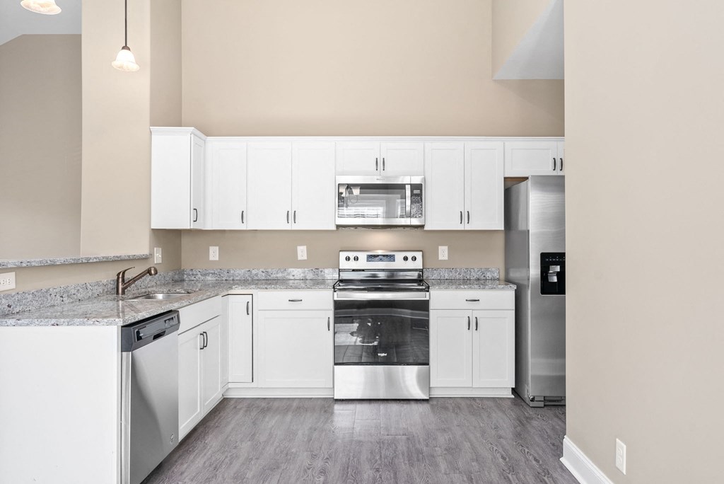 a kitchen with white cabinets and stainless steel appliances