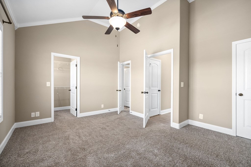an empty living room with a ceiling fan