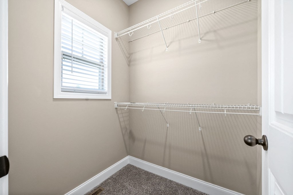 the closet in a small bathroom with a window