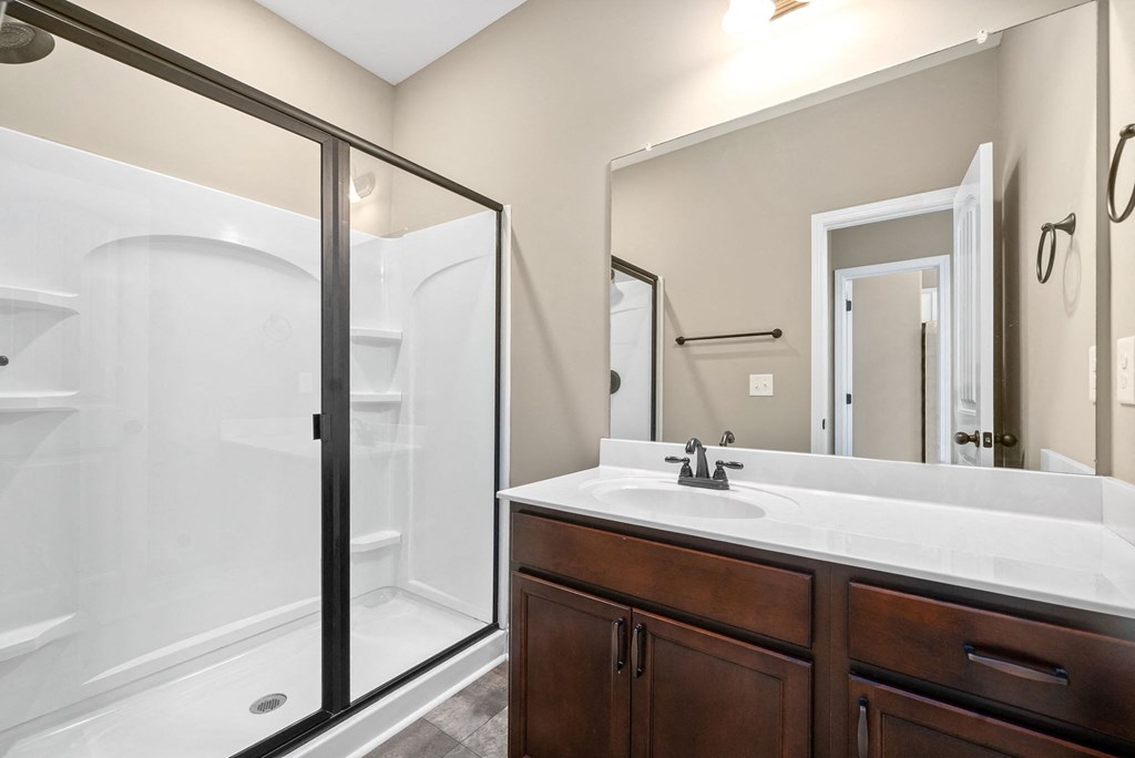 a bathroom with a shower and a sink and a mirror